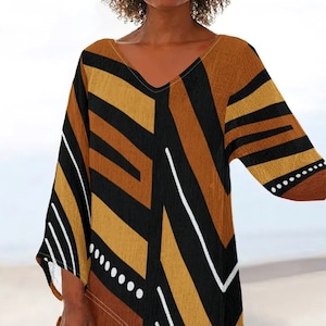 Peut inclure: Un haut tunique à col en V avec un motif géométrique dans les tons de marron, noir et jaune. Le haut présente un ourlet asymétrique et des manches trois-quarts avec des accents de points blancs. Le style est décontracté et bohème.