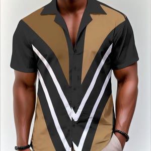 May include: Short-sleeved button-down shirt with a striking geometric design. The shirt features a black collar and sleeves, with a tan and black chevron pattern accented by white stripes. The shirt is buttoned down the front.