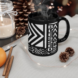 May include: Black coffee mug with a white geometric pattern and the word "Blessed" in white lettering.
