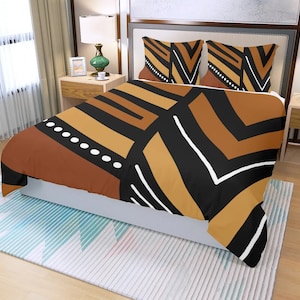 May include: A bed with a duvet cover and two pillowcases featuring a geometric pattern in shades of brown, black, and white. The design includes stripes, rectangles, and a dotted line. The bed is made up with a white bed skirt and sits on a patterned rug.
