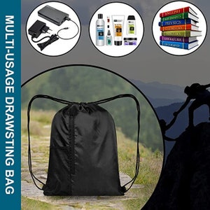 May include: A black drawstring bag with a zippered pocket and mesh side pockets. The bag is sitting on a path in a forest. The bag is a multi-usage drawstring bag.