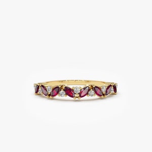 May include: A gold band ring featuring a row of marquise-shaped ruby stones and round diamonds.