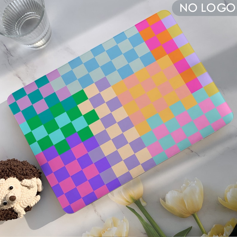 K&ouml;nnte beinhalten: Eine farbenfrohe karierte Laptop-Haut mit einem Patchwork-Design aus pastellblauen, gr&uuml;nen, violetten, rosa und gelben Quadraten.