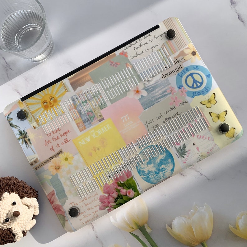 May include: A laptop cover with a collage of colorful images and text. The cover features a variety of images, including a sun, a palm tree, a globe, and flowers. The text on the cover includes quotes about love, hope, and life. The cover is made of a durable material and is designed to protect your laptop from scratches and bumps.