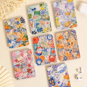 May include: Six rectangular notebooks featuring vibrant collage-style illustrations of coastal themes, including lemons, seafood, tropical fruits, and vintage-style postage stamps, with colorful patterns covering the entire front covers of each item.