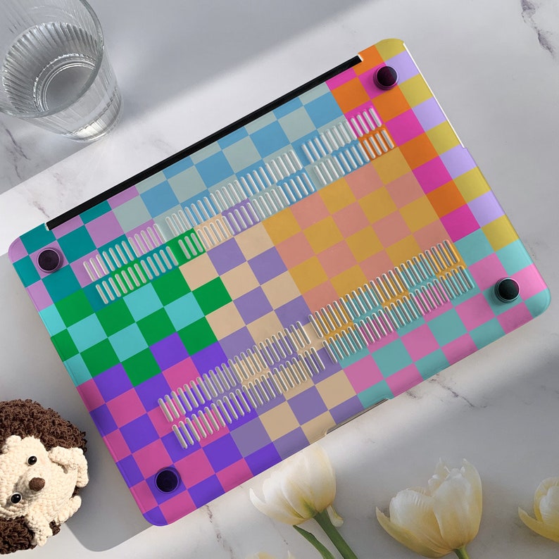 K&ouml;nnte beinhalten: Eine bunte karierte Laptop-Haut mit einer Vielzahl von Pastellfarben, darunter Rosa, Blau, Gr&uuml;n und Gelb. Die Haut hat ein kariertes Muster mit einer Vielzahl von Quadraten unterschiedlicher Gr&ouml;&szlig;e.