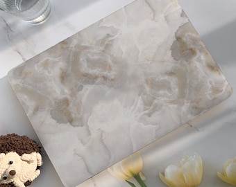 Peut inclure: Une peau de protection pour ordinateur portable en marbre blanc avec un motif de veines grises subtiles. La peau est conçue pour protéger la surface d'un ordinateur portable des rayures et de l'usure.