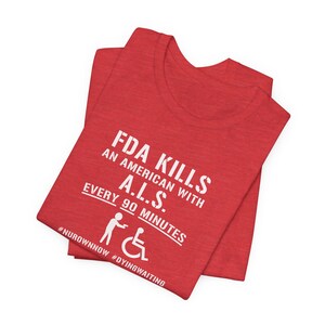 May include: Red t-shirt with white text that reads "FDA Kills An American With A.L.S. Every 90 Minutes" and a wheelchair symbol. The hashtags #NUROWNNOW and #DYINGWAITING are below the text.