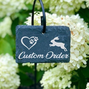 May include: A black slate garden marker with a white heart and paw print design, a white rabbit silhouette, and the text "Custom Order". The marker is attached to a black metal stake.