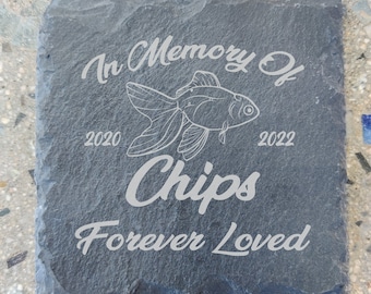May include: A black slate stone memorial with the inscription "In Memory Of Chips Forever Loved" and a goldfish illustration. The dates 2020 and 2022 are also included.