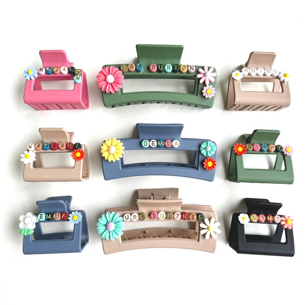 May include: Nine colorful plastic hair clips with a flower design and personalized lettering. Each clip has a different name or title, such as "Emma", "Mrs. Boltress", and "Bride".