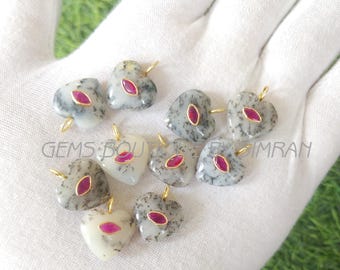 May include: A collection of heart-shaped pendants. Each pendant features a gold bail, a central oval-shaped red stone, and a speckled gray and white stone. The text "GEMS BOU" and "IMRAN" are visible.