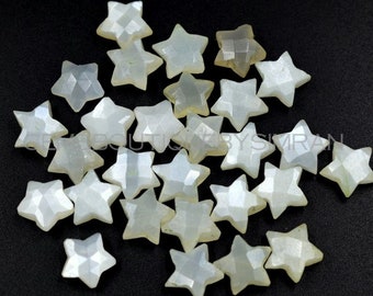 May include: A collection of white star-shaped gemstone cabochons. The stones have a pearlescent sheen and are faceted.