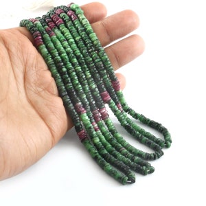 May include: A strand of green and pink gemstone beads. The beads are round and have a smooth, polished finish. The strand is approximately 18 inches long.