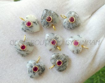 May include: Heart-shaped gemstone pendants with a gold bail. Each pendant features a central red gemstone set in a gold bezel. The heart-shaped stones are white with gray and black veining.