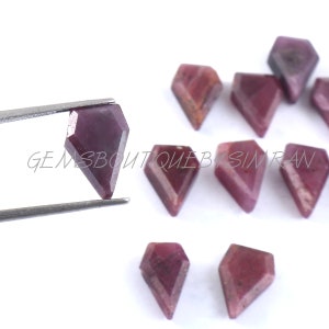 May include: A group of nine faceted, purple-red gemstone cabochons in a kite shape. The gemstones are approximately 10mm in length and 7mm in width.