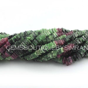 May include: A strand of green, black, and pink gemstone beads. The beads are rectangular and have a rough, natural finish. The beads are strung on a clear thread.