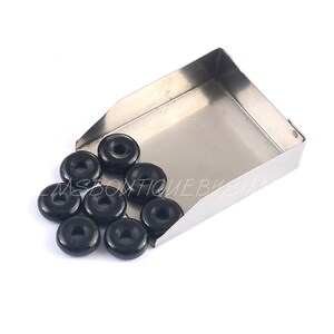 May include: A close-up of a metal scoop filled with black wooden beads. The beads are round with a hole in the center.