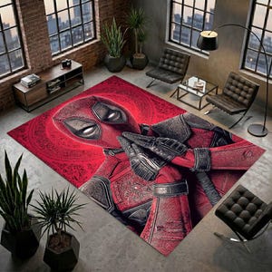 Può includere: Un tappeto rettangolare con una grande e dettagliata grafica del personaggio Deadpool in un costume rosso e nero con lenti oculari bianche. Il personaggio è raffigurato dal busto in su con le mani giunte su uno sfondo rosso vibrante.