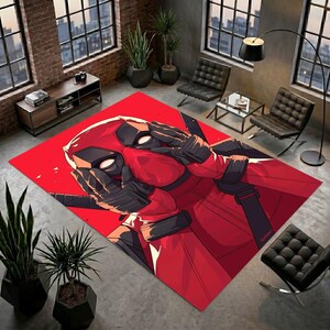 Può includere: Un tappeto rettangolare con una vivace illustrazione grafica rossa del personaggio Deadpool. Il design mostra il personaggio in primo piano, che indossa una maschera rossa e nera e guanti tattici neri, con le mani posizionate vicino al viso.