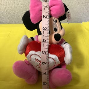 May include: A pink and red plush Minnie Mouse toy holding a red heart that says "You are my Valentine".