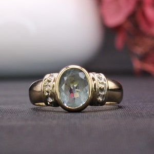 Oval Aquamarine ring bezel set in yellow gold