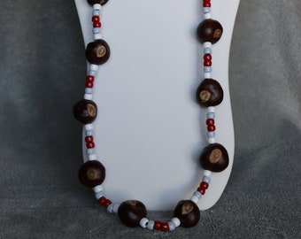 May include: A necklace made with brown buckeyes and red and white beads.