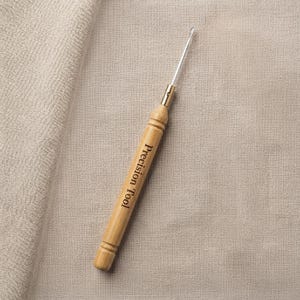 May include: A crochet hook featuring a light-colored wooden handle with the words Precision Tool engraved in black lettering. The tool has a slender, polished metal hook at the top, connected to the handle by a small, gold-toned metal ferrule.