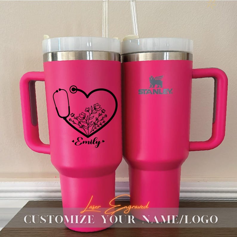 Close-up of a personalized 40oz powder-coated tumbler with a handle and straw. The laser engraving features a custom name in elegant script, a heart-shaped stethoscope design, and motivational nurse affirmations. The tumbler is shown in a professional setting, highlighting its durable finish and large capacity. Perfect gift for nurses and medical staff