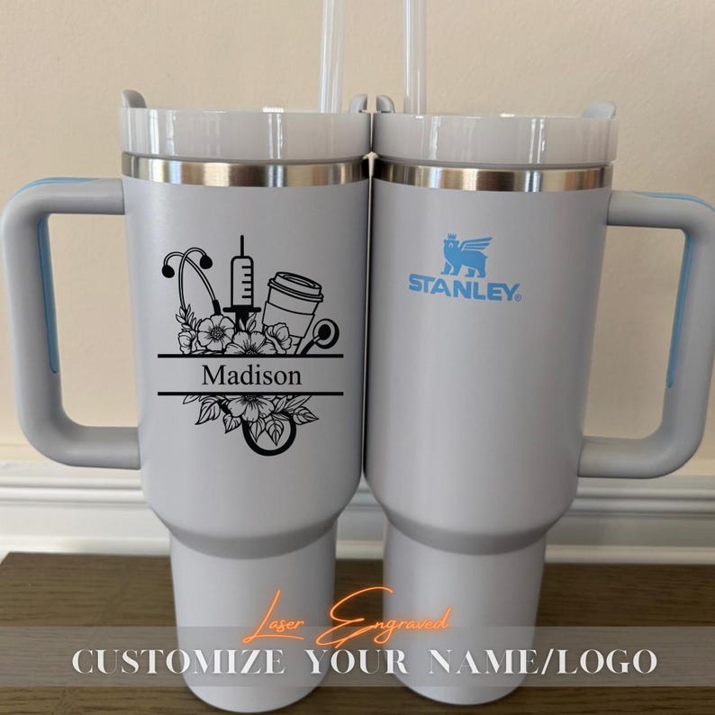 Close-up of a personalized 40oz powder-coated tumbler with a handle and straw. The laser engraving features a custom name in elegant script, a heart-shaped stethoscope design, and motivational nurse affirmations. The tumbler is shown in a professional setting, highlighting its durable finish and large capacity. Perfect gift for nurses and medical staff