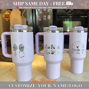 Close-up of a personalized 40oz powder-coated tumbler with a handle and straw. The laser engraving features a custom name in elegant script, a heart-shaped stethoscope design, and motivational nurse affirmations. The tumbler is shown in a professional setting, highlighting its durable finish and large capacity. Perfect gift for nurses and medical staff.