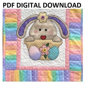 May include: A digital download PDF pattern for a quilted Easter bunny in a basket. The bunny is brown with purple ears and a pink nose. The basket is yellow with a pink flower and blue and purple eggs. The background is a patchwork of pastel colors.