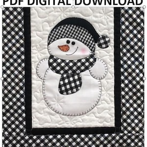 Może przedstawiać: Biały bałwan w czarno-białą kratę. Bałwan jest otoczony czarno-białą kratą.