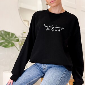May include: Black sweatshirt with white text that reads "I'm only here for the apres ski".