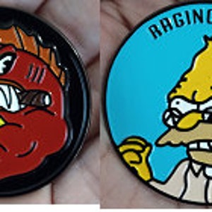 Peut inclure: Deux épingles en émail rondes. La première épingle est noire avec un cercle jaune au centre. Le cercle a le texte "Hell Fish" écrit en cercle autour d'un poisson rouge avec un cigare dans la bouche. La deuxième épingle est bleue avec le texte "Raging Abe" écrit en cercle autour d'un personnage de dessin animé jaune avec une barbe et des lunettes.