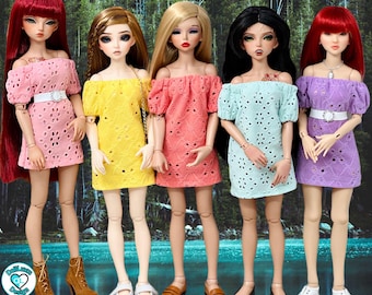 May include: Five dolls wearing different colored eyelet peasant dresses. The dresses are all off-the-shoulder and have a scalloped hem. The dolls are all wearing different shoes, including white sneakers, brown loafers, and brown boots. The dolls are standing in front of a green and blue background. The text "Eyelet Peasant Dress 1:4" is at the top of the image.
