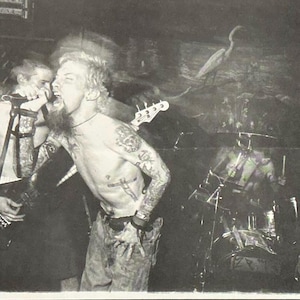 May include: Black and white concert poster featuring the band Avail. The top of the poster has the band's name in a distressed font. The image shows the band performing live. The bottom of the poster has the Lookout Records logo and address.