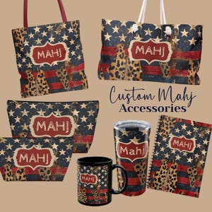 May include: Collection of custom accessories featuring a patriotic design with stars, stripes, and leopard print. Includes tote bags, cosmetic bags, a tumbler, a mug, and a notebook, all with the text "MAHJ".