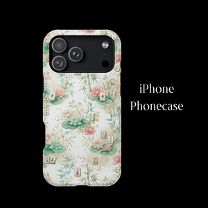 May include: An iPhone phonecase featuring a light-colored background with a repeating pattern of pink lotus flowers, green lily pads, bamboo stalks, and Mahjong tiles. The text iPhone Phonecase is displayed to the right of the phonecase.