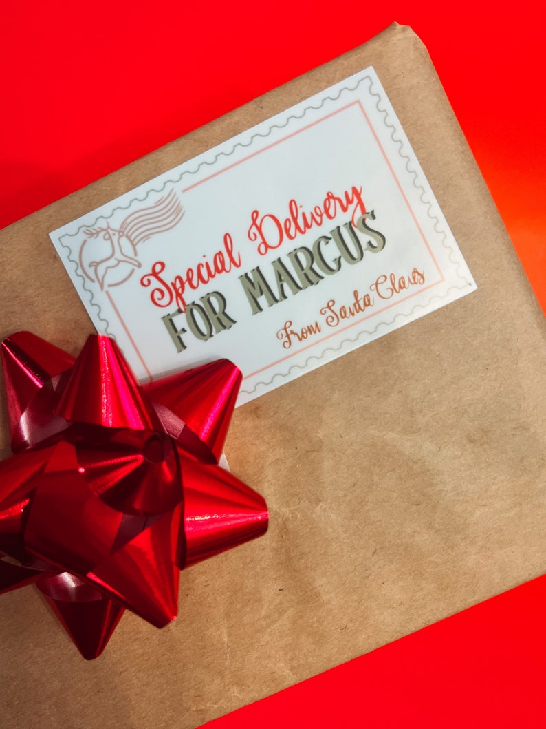 K&ouml;nnte beinhalten: Eine braune Papiert&uuml;te mit einer roten Schleife und einem wei&szlig;en Etikett mit der Aufschrift "Special Delivery for Marcus From Santa Claus".