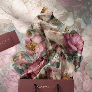 May include: A floral-themed gift set featuring a scarf, gift bag, and card. The scarf displays a pattern of pink and cream peonies with green leaves. The gift bag and card are a deep rose color and feature the text "OAK & WILLOW".