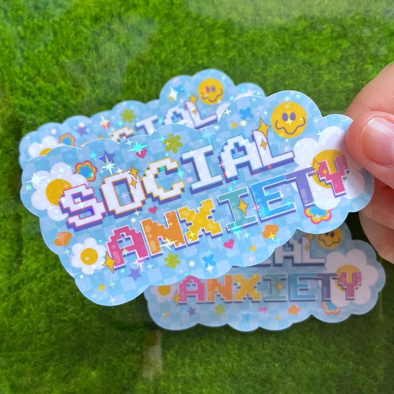 May include: A set of four blue and white stickers with a pixelated design. The stickers feature the text "SOCIAL ANXIETY" in rainbow colors with a glittery effect.