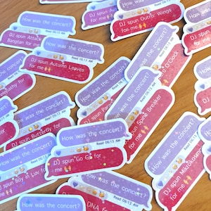 May include: A collection of die-cut stickers shaped like mobile messaging bubbles. Each sticker features a purple bubble with the text How was the concert? and a pink bubble with text such as DJ spun Outro: Tear for me, Wings, or DNA.