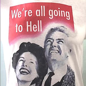 May include: White t-shirt featuring the text "We're all going to Hell" in a red rectangle. Below the text is a black and white image of a smiling woman and man looking upwards.