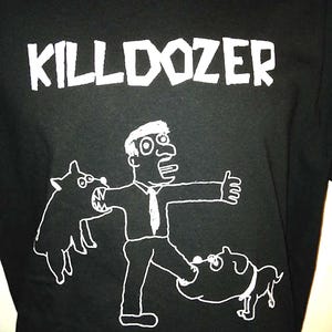 May include: Black t-shirt with a white graphic of a man kicking a dog. The text "KILLDOZER" is printed above the graphic.
