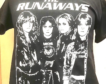 May include: Black t-shirt with a white graphic of the band "The Runaways". The graphic features four women in black and white, with the band's name in large white letters at the top.