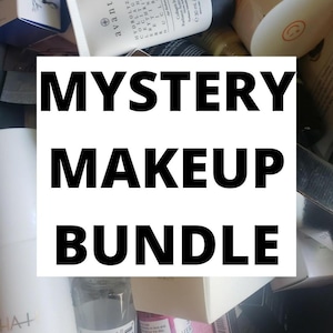 Op de afbeelding: Een verzameling schoonheidsproducten, waaronder huidverzorging en make-up artikelen, met de tekst "MYSTERY MAKEUP BUNDLE" in een witte rechthoek. Verschillende containers en dozen zijn zichtbaar, wat wijst op een verscheidenheid aan producten.