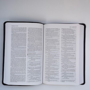 K&ouml;nnte beinhalten: Offene Bibel mit zwei Seiten, die Text aus dem Buch der Richter zeigen. Die linke Seite zeigt die Verse 4-5 und die rechte Seite zeigt die Verse 29-30. Der Text ist in Schwarzwei&szlig;.