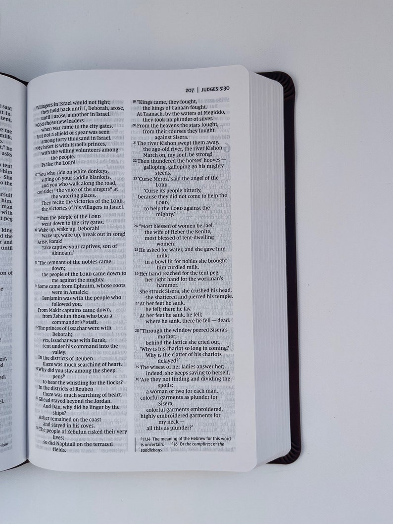 K&ouml;nnte beinhalten: Nahaufnahme einer Seite aus einem Bibelbuch, Richter 5:30. Der Text ist in Schwarzwei&szlig; und beschreibt die Geschichte von Jael, einer Frau, die Sisera, einen kanaanitischen Heerf&uuml;hrer, t&ouml;tete, indem sie ihm einen Zeltpflock in den Kopf schlug.