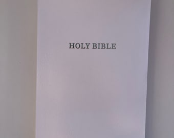 May include: A white leather-bound Holy Bible.